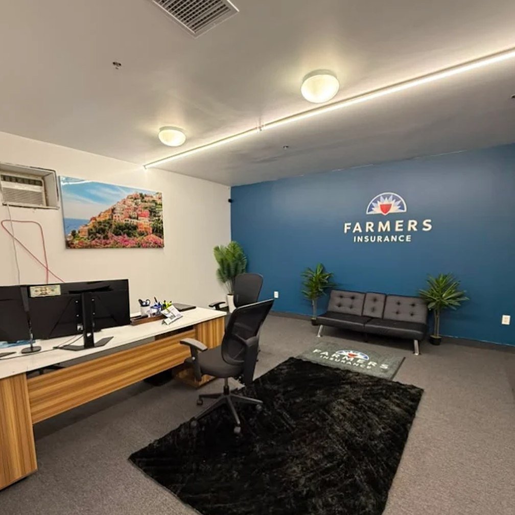 The Sheikh Insurance office in Upper Darby — seating area beneath the Farmers Insurance wall logo, with the agent's desk alongside